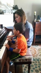 Nicole Mullinax and child at piano.
