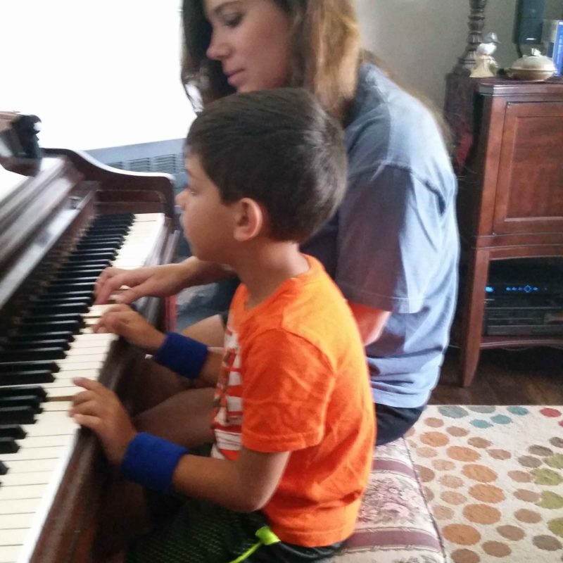 Nicole Mullinax and child at piano.