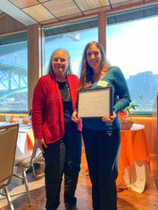 Photo of 2021 Greenberg Scholarship Award Winner, Jaime Hodge, posing with Dr. Cathy Hammon, holding certificate and smiling. 