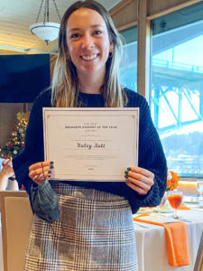 Photograph of EPC Graduate Student of the Year Award Winner, Haley Ault, holding certificate and smiling