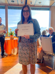 Photo of Graduate Student of the Year Award Winner, Kristin Lucas, holding certificate and smiling. 