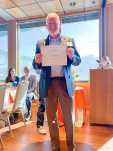 Photo of Graduate Student of the Year Award Winner, Tim Waldo, holding certificate and smiling.