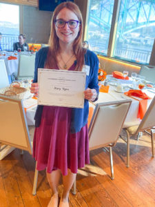 Photo of Leadership and Service Excellence Award Winner, Mary Wynn, holding certificate and smiling